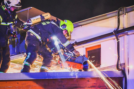 Feuerwehrleute schneiden das Dach auf
