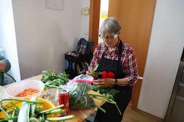 Helferin beim Gemüse putzen.