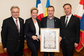Bgm. Andreas Babler, Vizebgm. Franz Gartner, STR*in Sandra Akranidis-Knotzer und Herr Racz bei der Übergabe der Urkunde.
