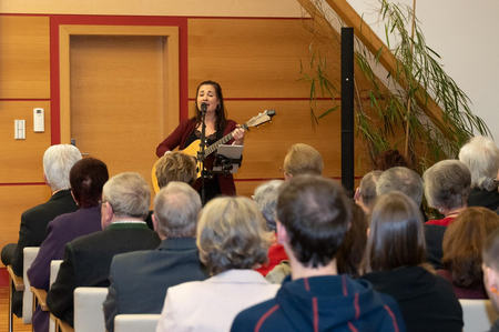 Eine Sängerin mit Gitarre bei der feierlichen Überreichung von Ehrenzeichen im Rathaus.