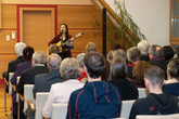 Mona Weinmeister spielt Gitarre bei der feierlichen Überreichung der goldenen Ehrenzeichen im Rathaus.