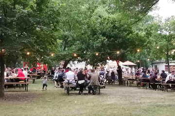 Besucher auf Bierzeltgarnituren.