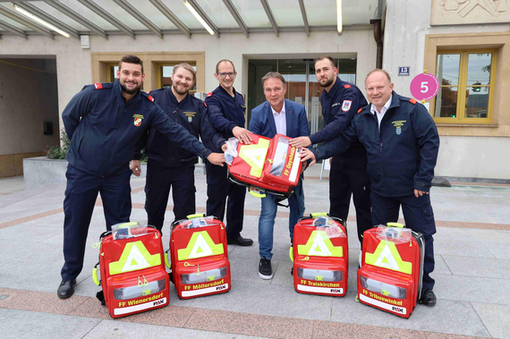 SB Patrick Hauer von der FF Wienersdorf, ASB Patrick Posch von der FF Möllersdorf, LM Markus Falli der FF Oeynhausen, Bgm. Andreas Babler, SB Mario Diensthuber von der FF Traiskirchen Stadt und HBI Stefan Mitheis von der FF Tribuswinkel mit den neuen Rucksäcken