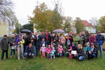 Eltern-Kinder-Gruppe bei der Lebensbaumpflanzung.