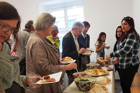 Besucher*innen bei der Verköstigung.