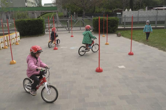 Kleinkinder fahren auf woom-Laufrädern durch einen Parcours