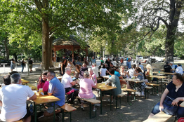 Gäste sitzen auf Heurigengarnituren im Stadtpark Traiskirchen
