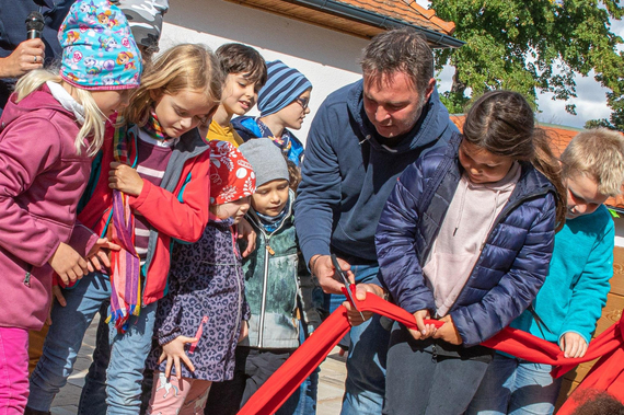 Bürgermeister Andreas Babler schneidet gemeinsam mit den Kindern das rote Band zur Eröffnung des KALO! - KinderabenteuerLabors durch