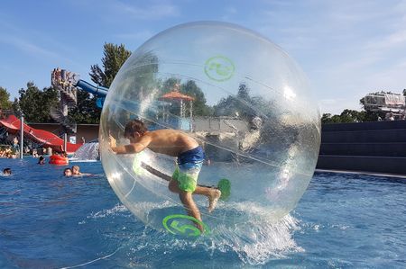 Jugenlicher in Plastikkugel beim Ferienspiel Traiskirchen im Aqua Splash.