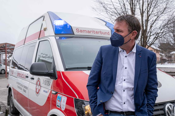 Bgm Andreas Babler lehnt an einem Fahrzeug des Samariterbundes