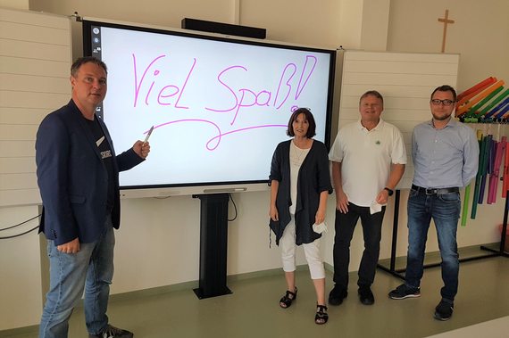 Bgm. Andeas Babler, NMS-Direktorin Ulrike Sauberer, Pädagoge Dietrich Reinfrank, STR Clemens Zinnbauer vor einem Smartboard.