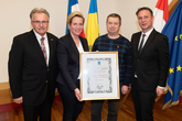 Bgm. Andreas Babler, Vizebgm. Franz Gartner, STR*in Sandra Akranidis-Knotzer und Herr Sauberer bei der Übergabe der Urkunde.