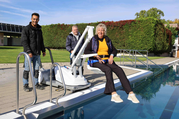 Mohammed Ibrahim, Mario Konorsa & Petra Bauer demonstrieren die Funktionsweise des Schwimmbadliftes