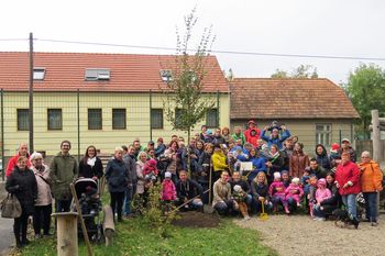 Eltern-Kinder-Gruppe bei der Lebensbaumpflanzung.