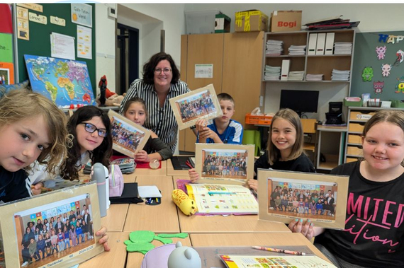 Bürgermeisterin Sabrina Divoky präsentiert gemeinsam mit einigen Kindern die Klassenfotos.