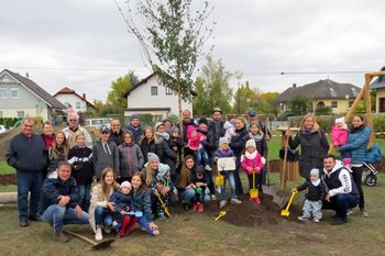 Eltern-Kinder-Gruppe bei der Lebensbaumpflanzung.