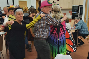 Besucher:innen des Aktiv Cafe tanzen Polonaise