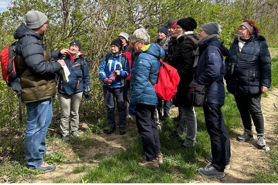 Teilnehmerinnen und Teilnehmer der Vogelexkursion verschiedenen Alters im Wald