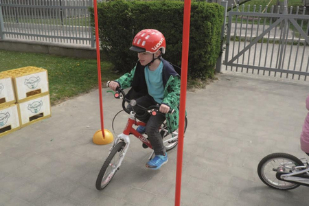 Ein Kind fährt auf einem woom-Laufad durch einen Parcours